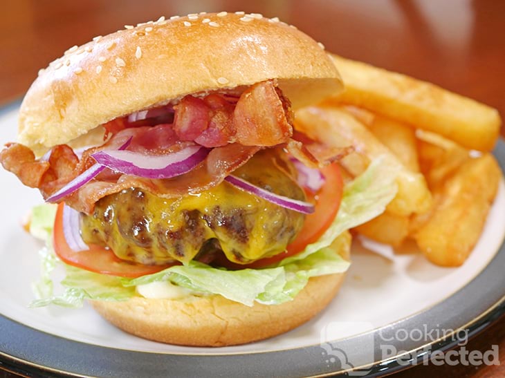 Air fried burger served inside a burger bun with lettuce, tomato, bacon, cheese