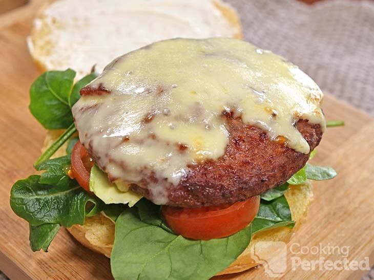 Cooked frozen hamburger on a burger bun with lettuce and tomato.